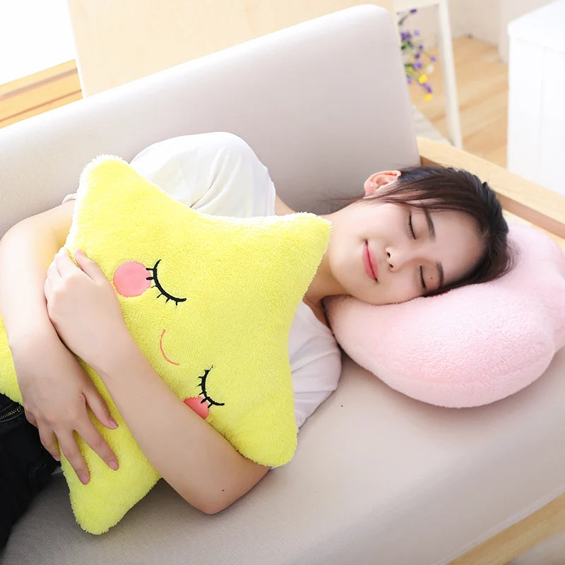 Person lying on a couch with a yellow star-shaped kawaii pillow and a pink neck pillow.