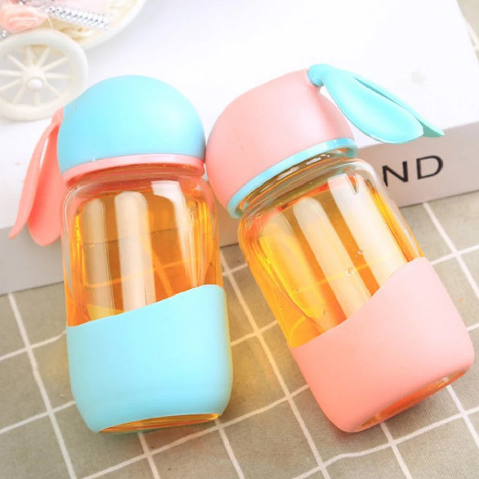 Two colorful kawaii water bottle with on a tiled surface.