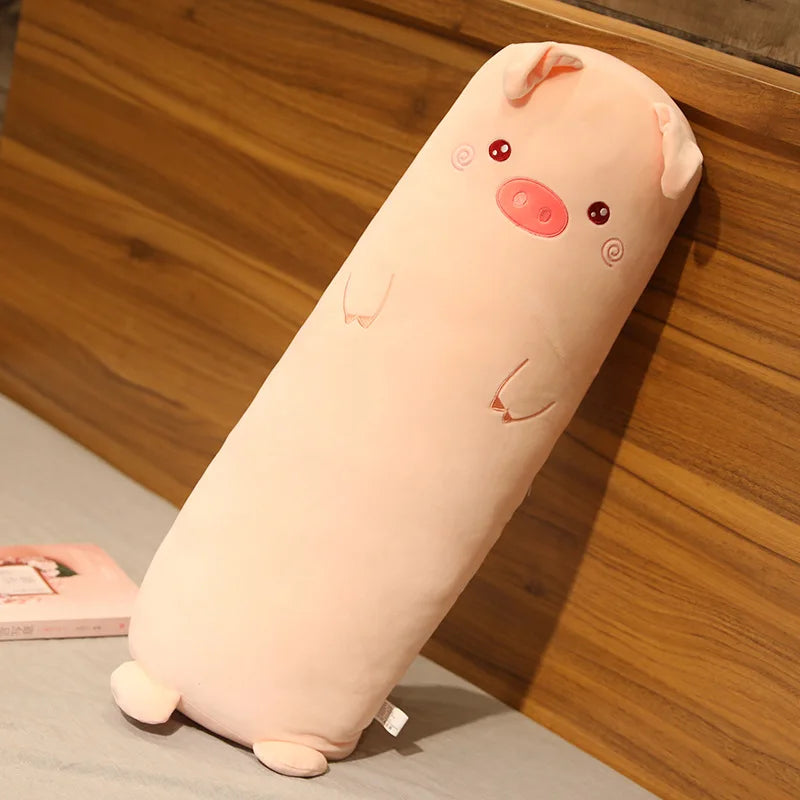 Cylindrical kawaii plush toy shaped like a pig on a wooden surface