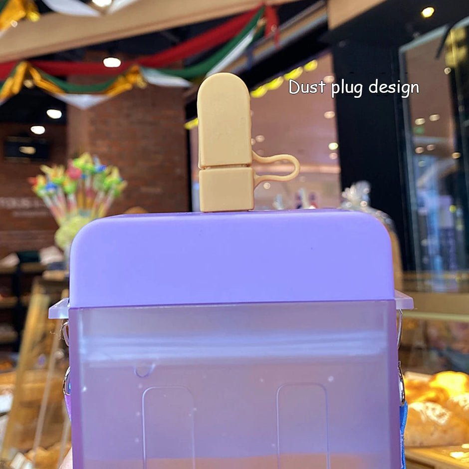 Purple kawaii water bottle with a beige dust plug design on a blurred indoor background