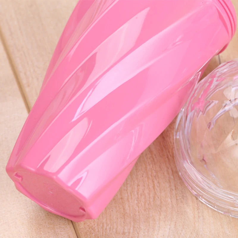 Pink plastic kawaii water bottle with a clear lid on a wooden surface