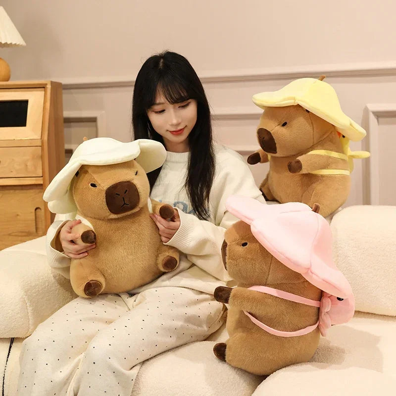 Woman sitting on a bed with three large kawaii plush toys resembling bears wearing hats.