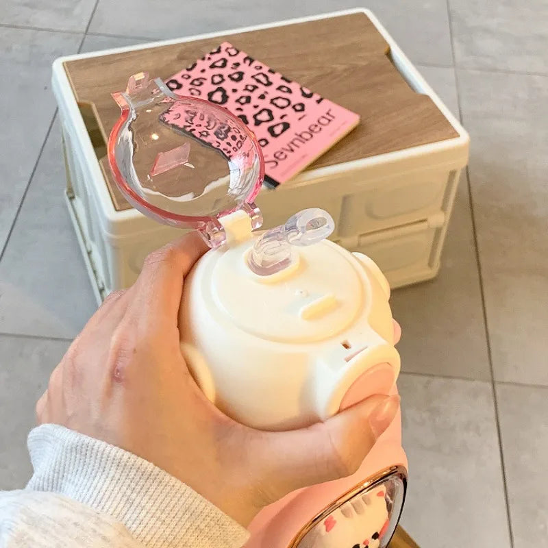 Hand holding a white kawaii mug with a pink leopard print item in the background