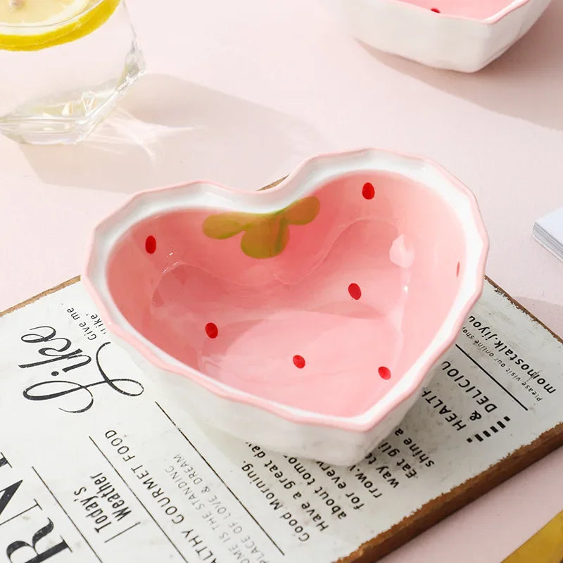 A strawberry heart shaped kawaii bowl on a table