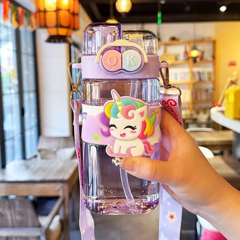 Colorful kawaii water bottle with a unicorn design held in a hand, blurred restaurant interior in the background
