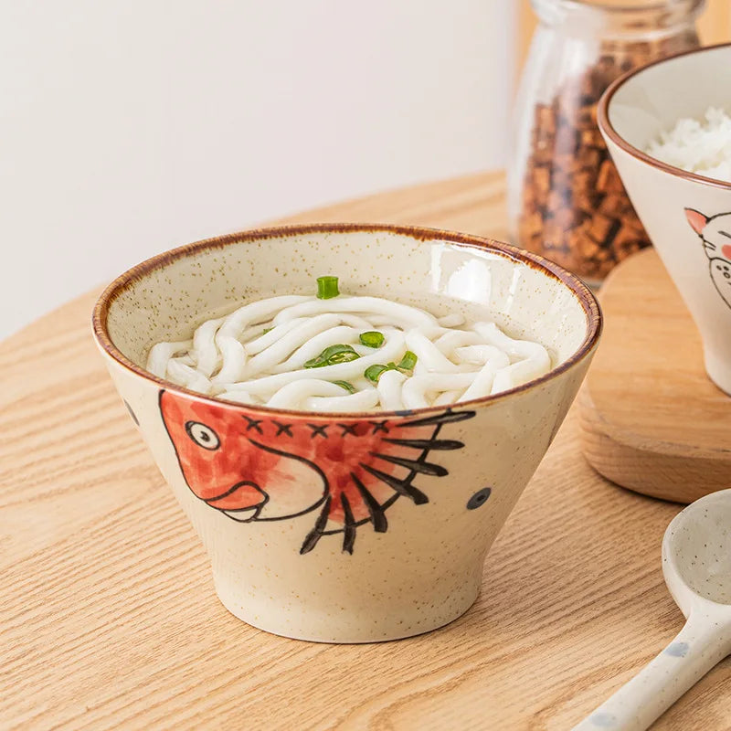Ceramic kawaii ramen bowl with udon noodles and fish design on a wooden surface