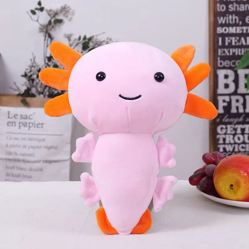 Plush toy axolotl with orange gills on a white surface