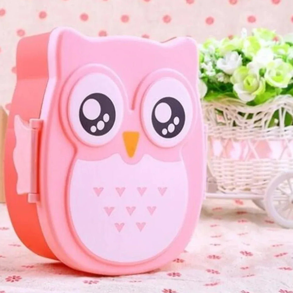 Pink owl-shaped kawaii food container on a floral surface with a decorative background