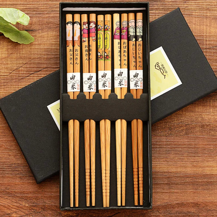 Set of wooden kawaii chopsticks in a black box on a wooden surface