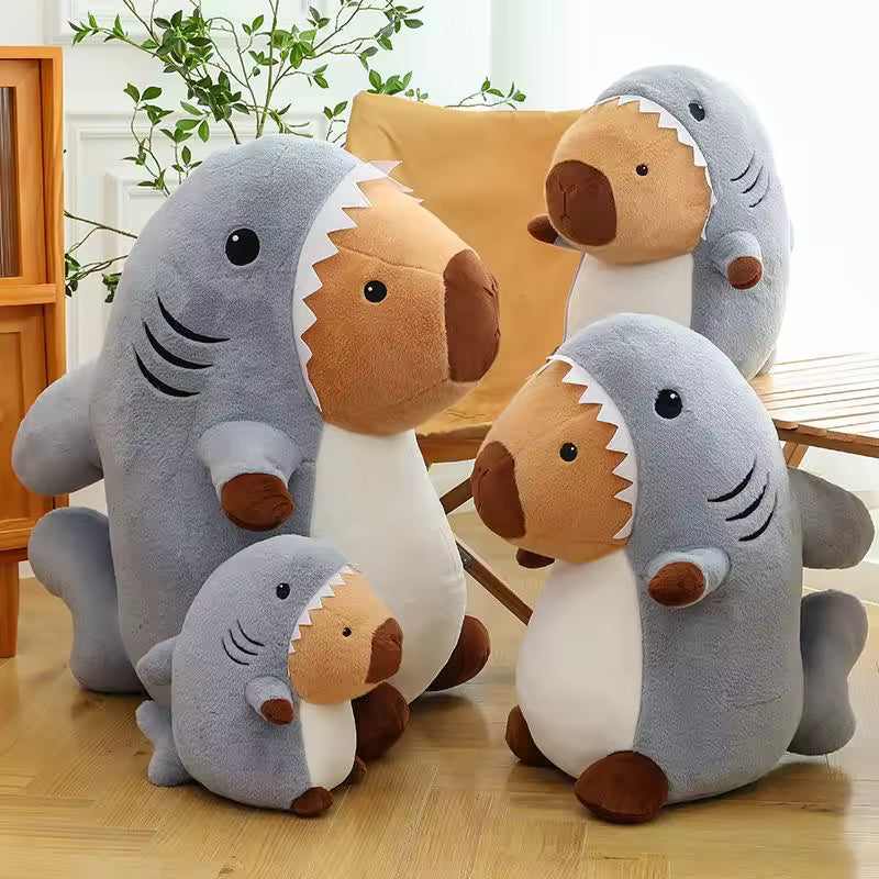 Set of kawaii plush shark toys on a wooden floor with a chair and plant in the background.