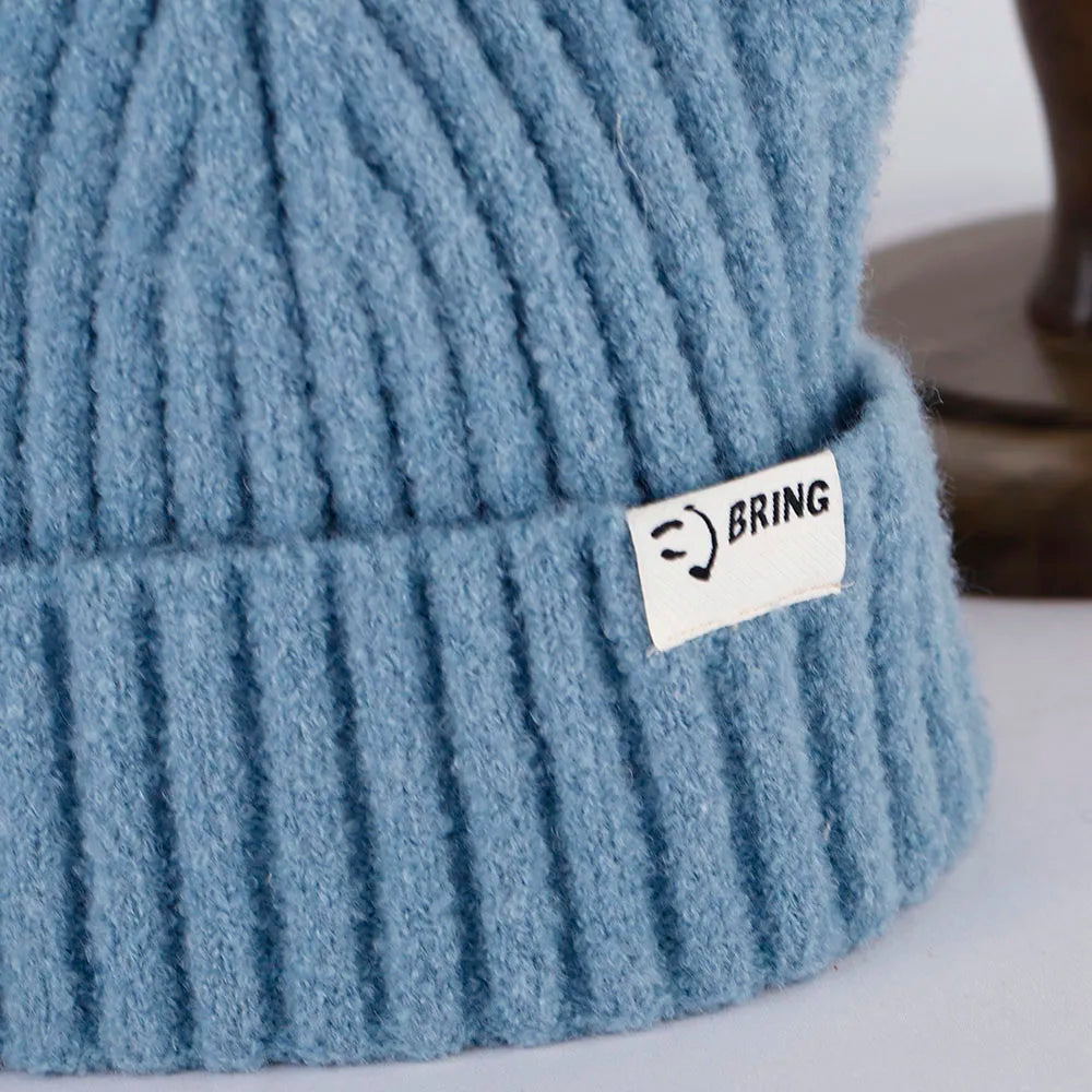 Blue knit Kawaii beanie with a label on a light background