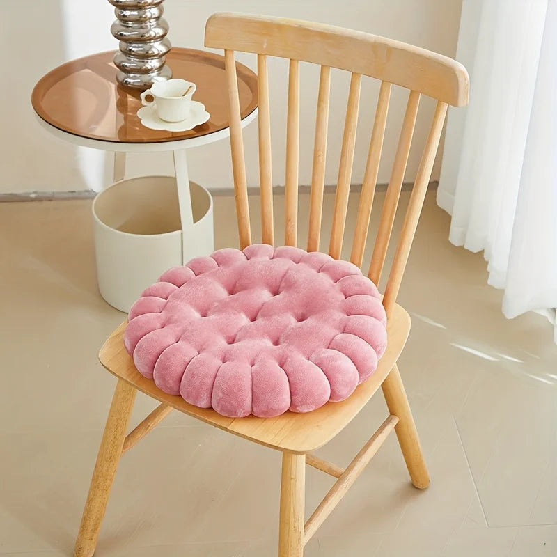 Pink kawaii cushion on a wooden chair with a small round table in the background