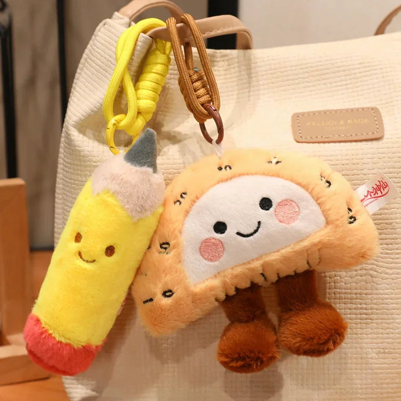 Two kawaii plush keychains, one yellow and one brown with a face, hanging from a beige bag.