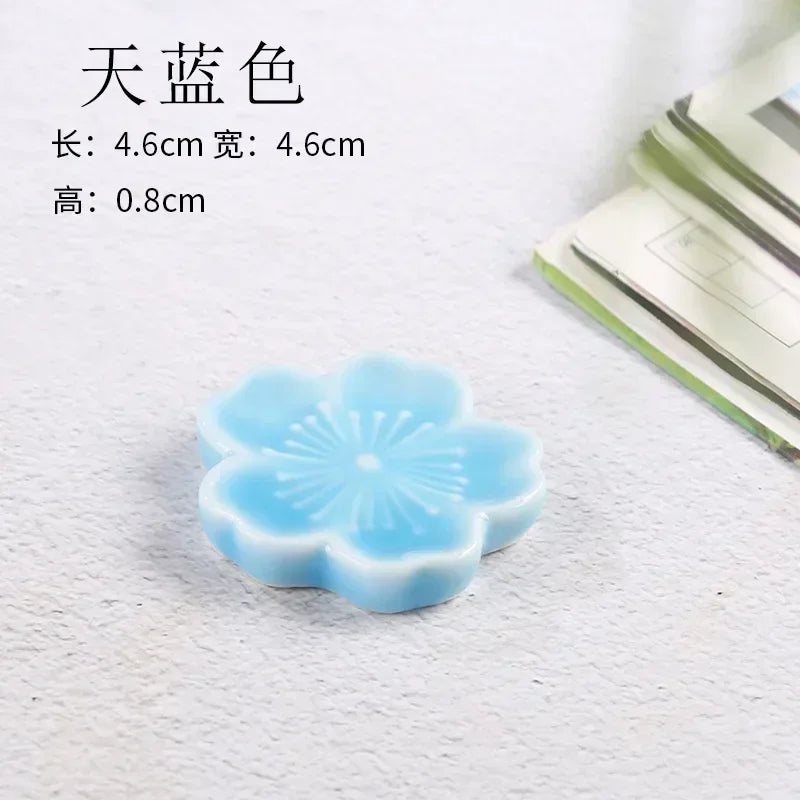 Blue flower-shaped kawaii chopstick holder on a textured surface with dimensions displayed.