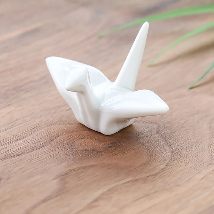 A white kawaii chopstick holders on a wooden table