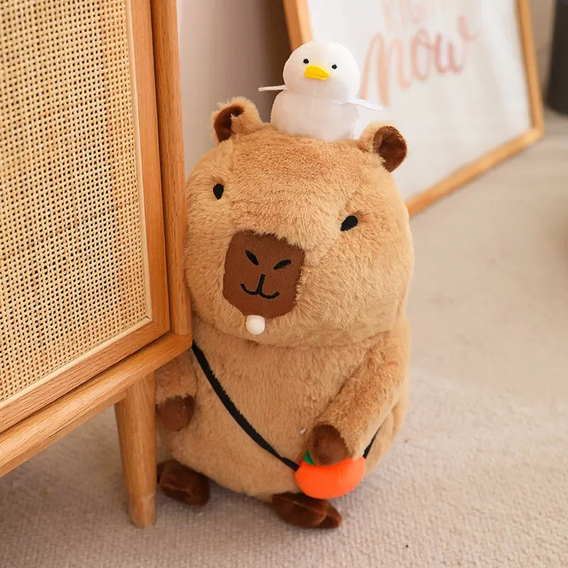 Plush toy resembling a kawaii bear with a smaller duck-like toy on its back, sitting on a carpeted floor.