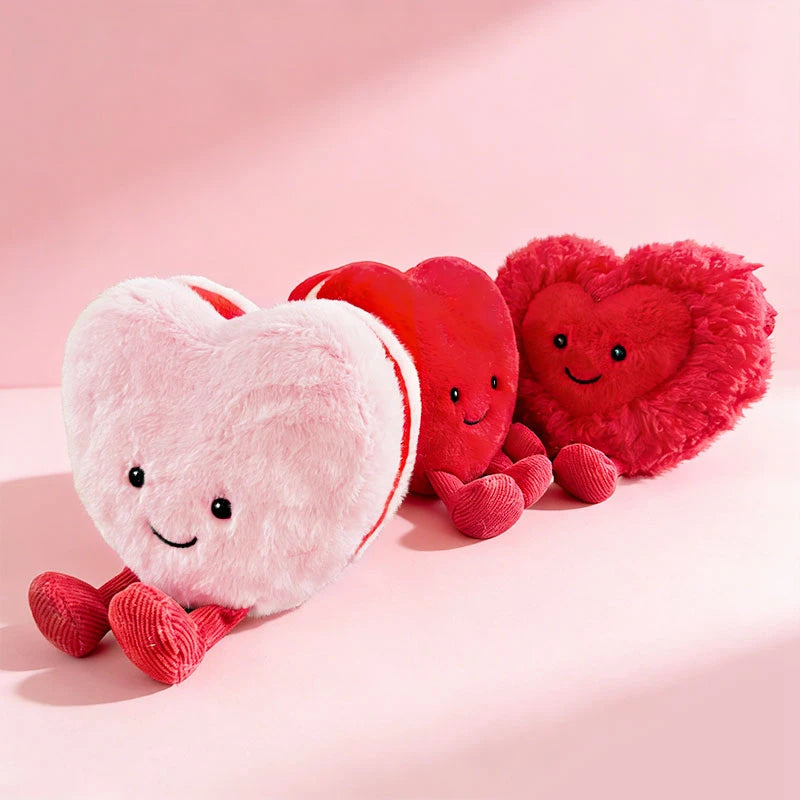 Heart-shaped kawaii plush toys in pink, red, and white on a pink background