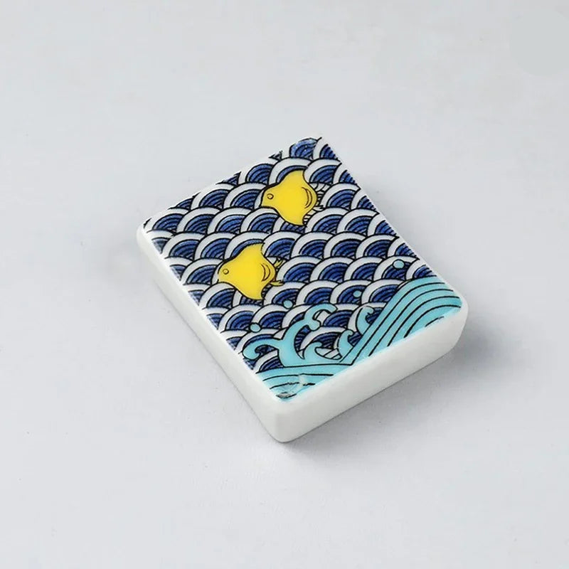 Rectangular kawaii chopstick holders with wave and fish pattern on a light gray background