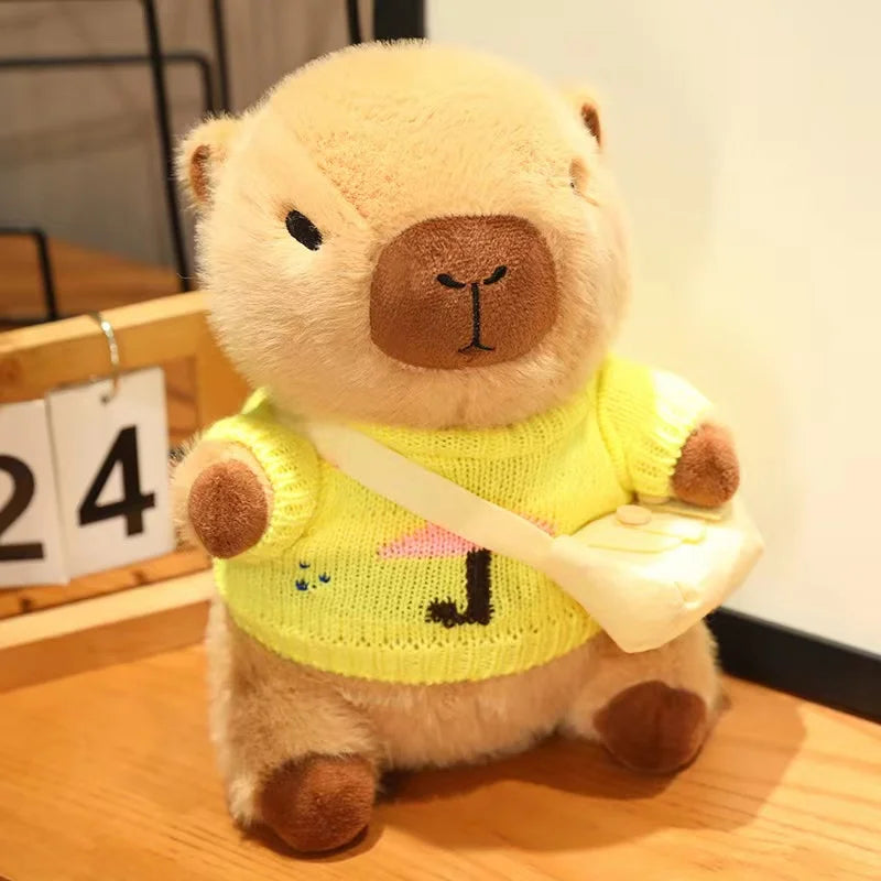 Kawaii plush toy bear wearing a yellow sweater with a pink heart on a wooden surface.