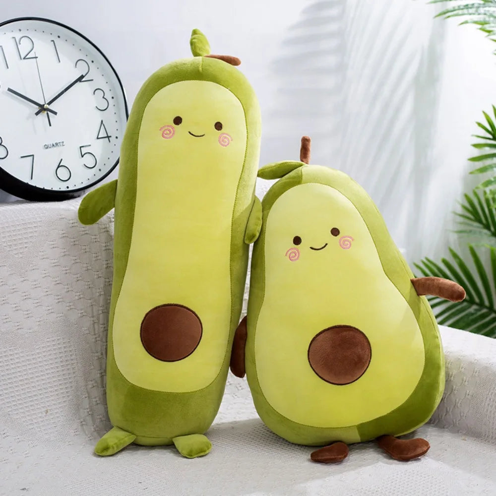 Two avocado-shaped kawaii plush toys on a white surface with a clock in the background.