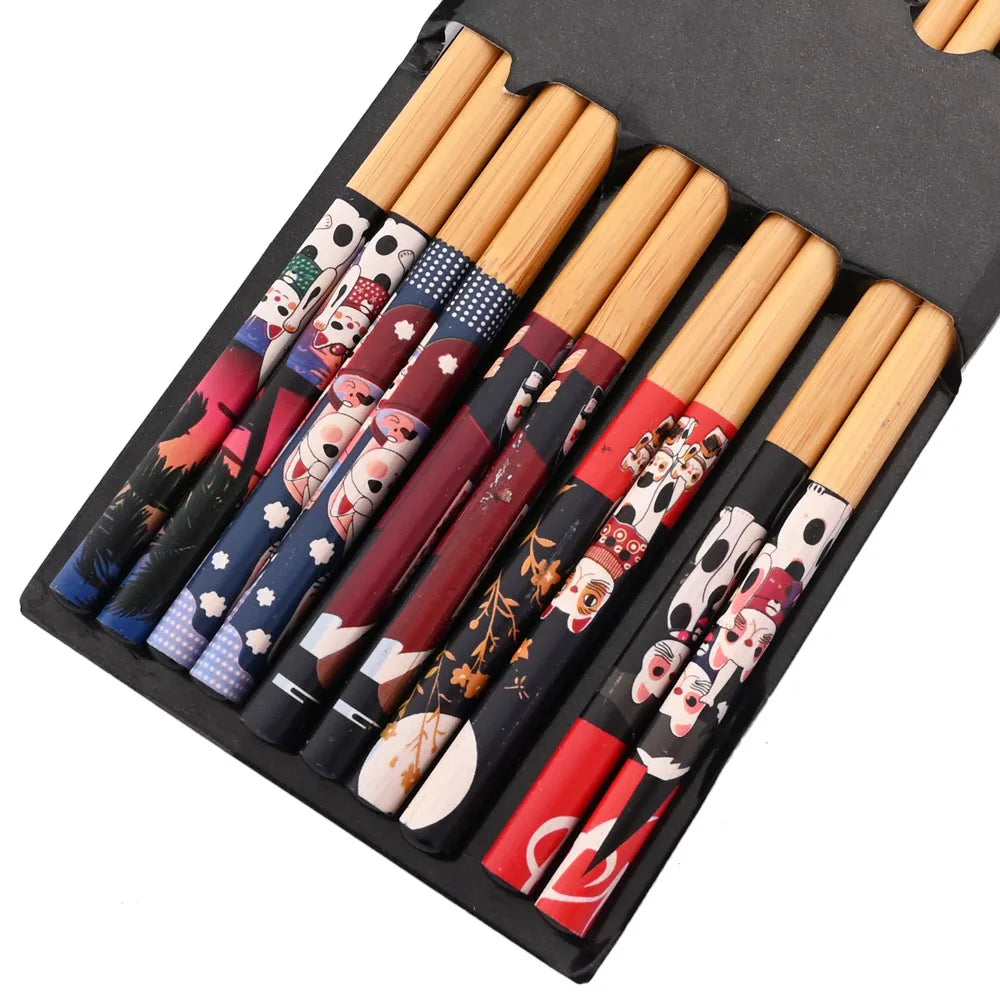 Set of wooden kawaii chopsticks with colorful decorative handles in a black case.