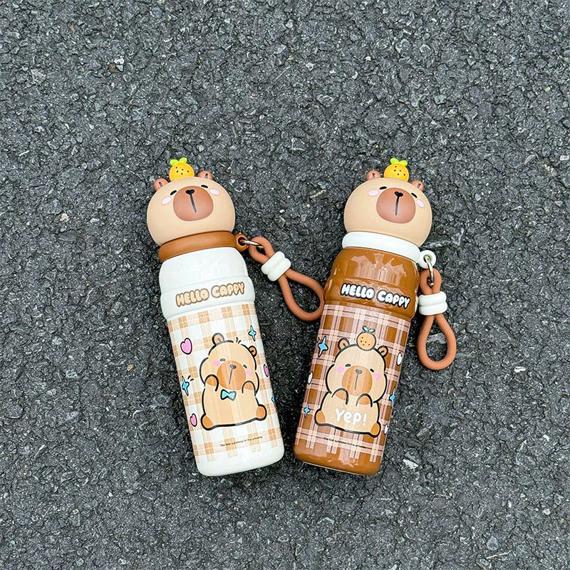 Two cartoon bear-themed kawaii water bottles with keychains on a textured surface