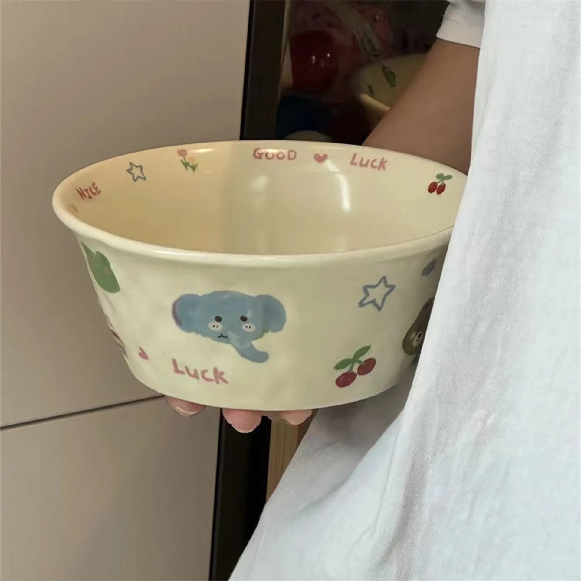 Person holding a ceramic kawaii ramen bowl with cartoon design and text