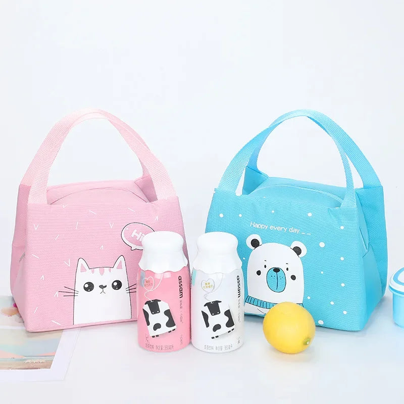 Two cartoon-themed kawaii lunch bags, one pink and one blue, with matching bottles on a light gray background.
