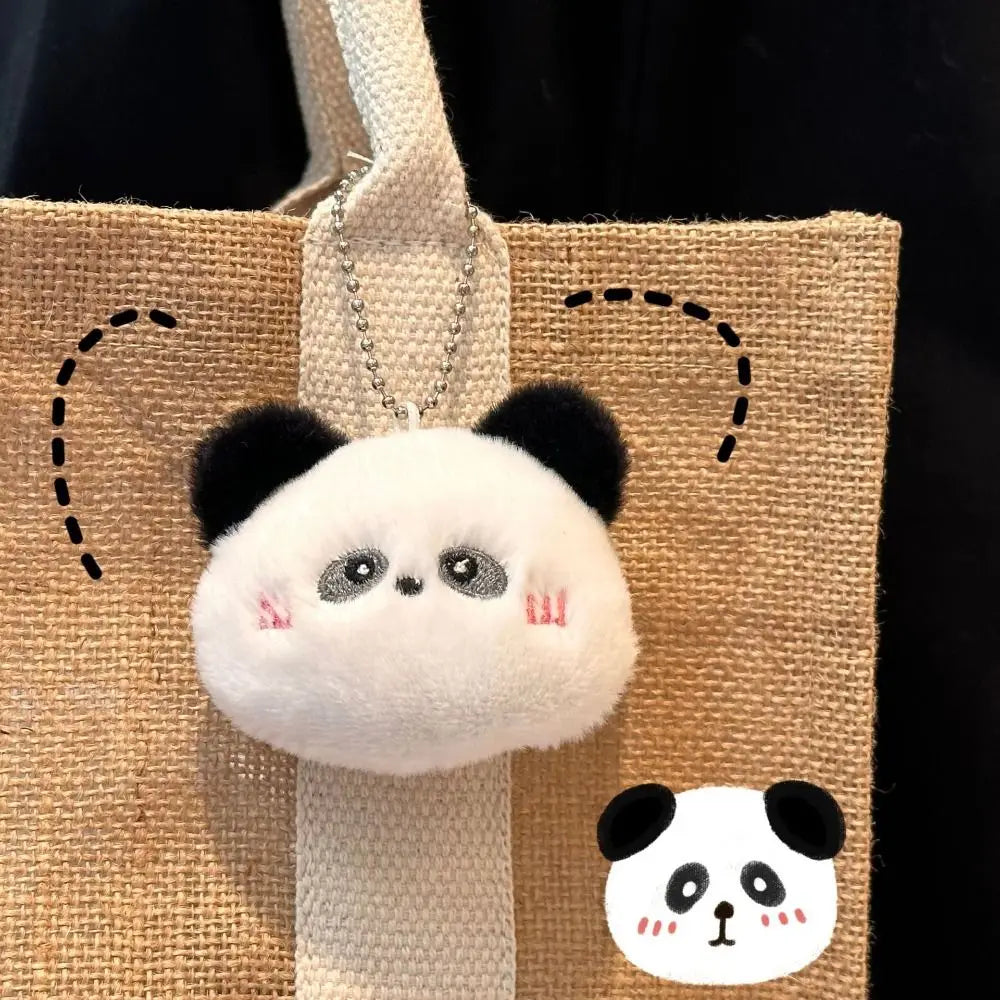 Kawaii panda-shaped keychain attached to a woven bag with a small panda illustration.