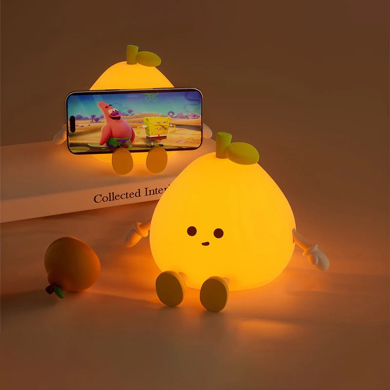 Cute lemon-shaped kawaii night light with a phone on a wooden surface