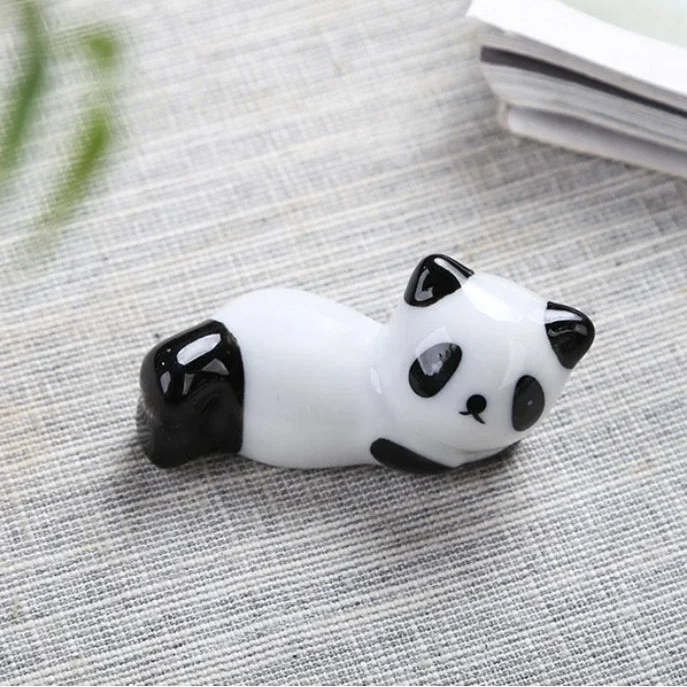 Panda-shaped kawaii chopstick holders on a textured surface with dimensions displayed
