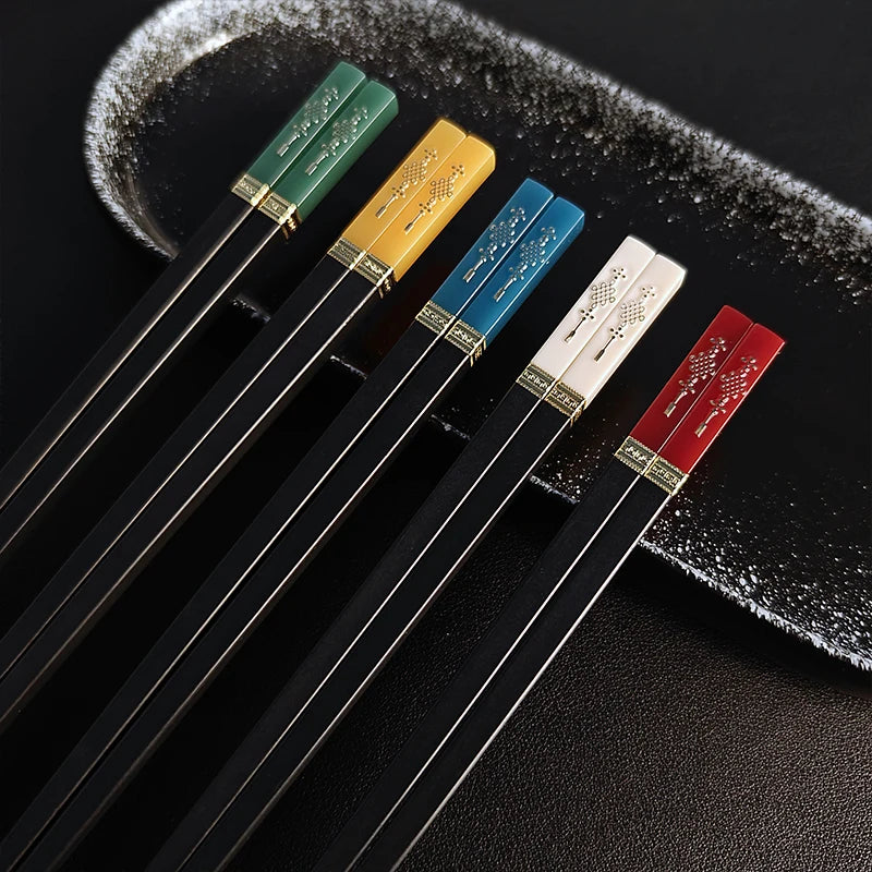 Set of black kawaii chopsticks with colorful handles on a textured black surface