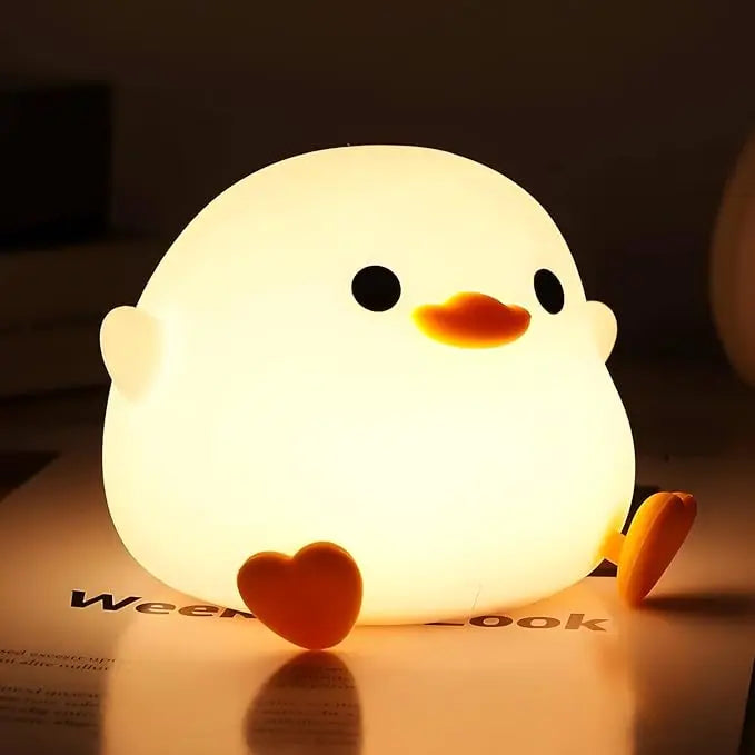 Cute chick-shaped kawaii night light on a surface with a dark background