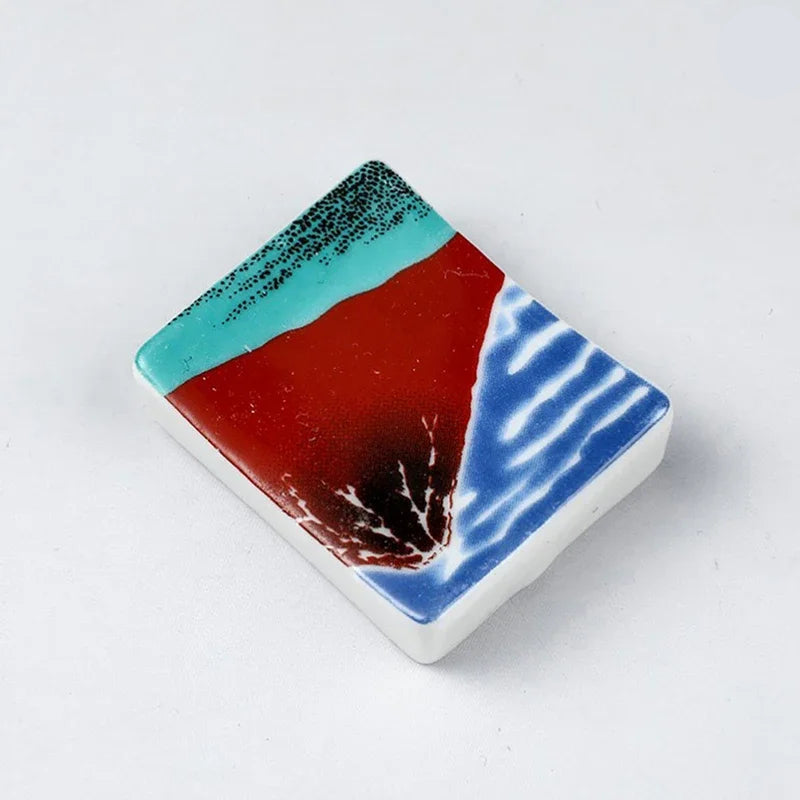 Square ceramic kawaii chopstick holders with multicolored design on a white background