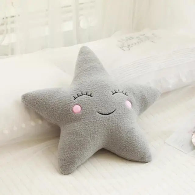 Gray star-shaped kawaii pillow with a smiling face on a white surface