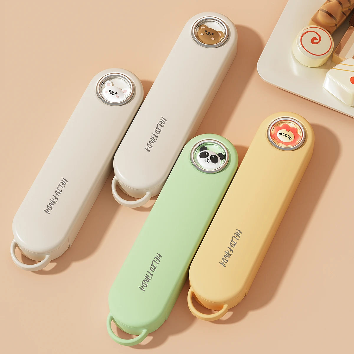Four colorful kawaii utensils with animal-themed designs on a beige background