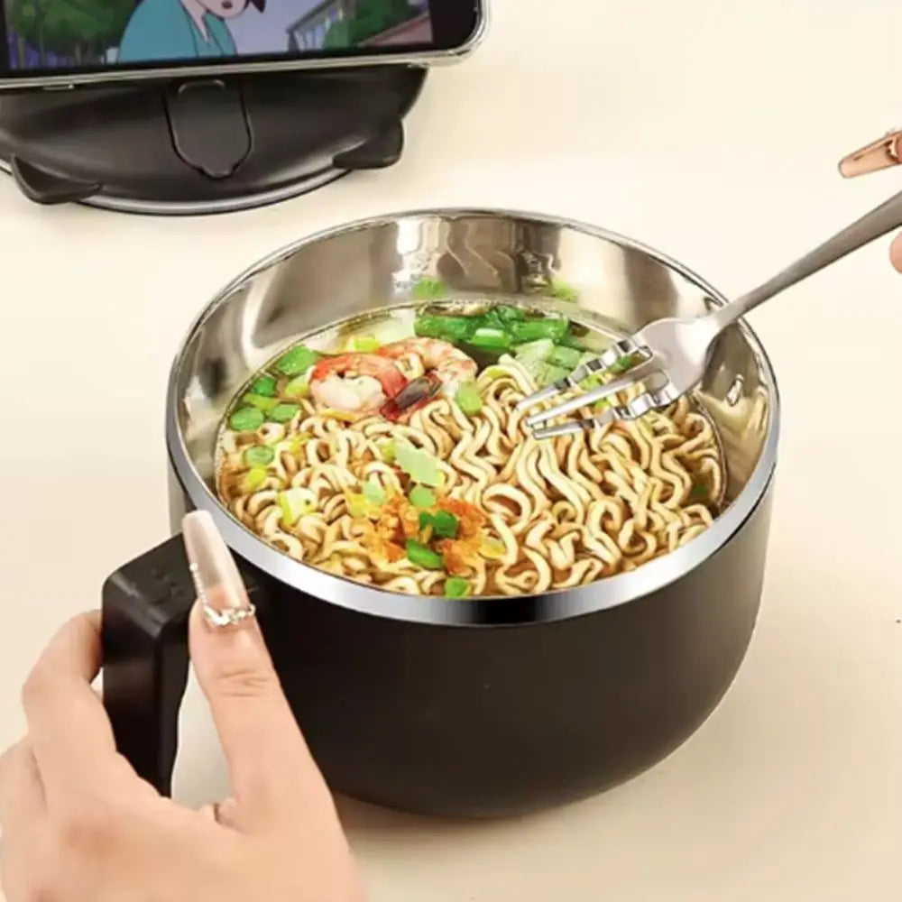 Stainless steel kawaii ramen bowl with ramen noodles, vegetables, and a fork on a beige surface.