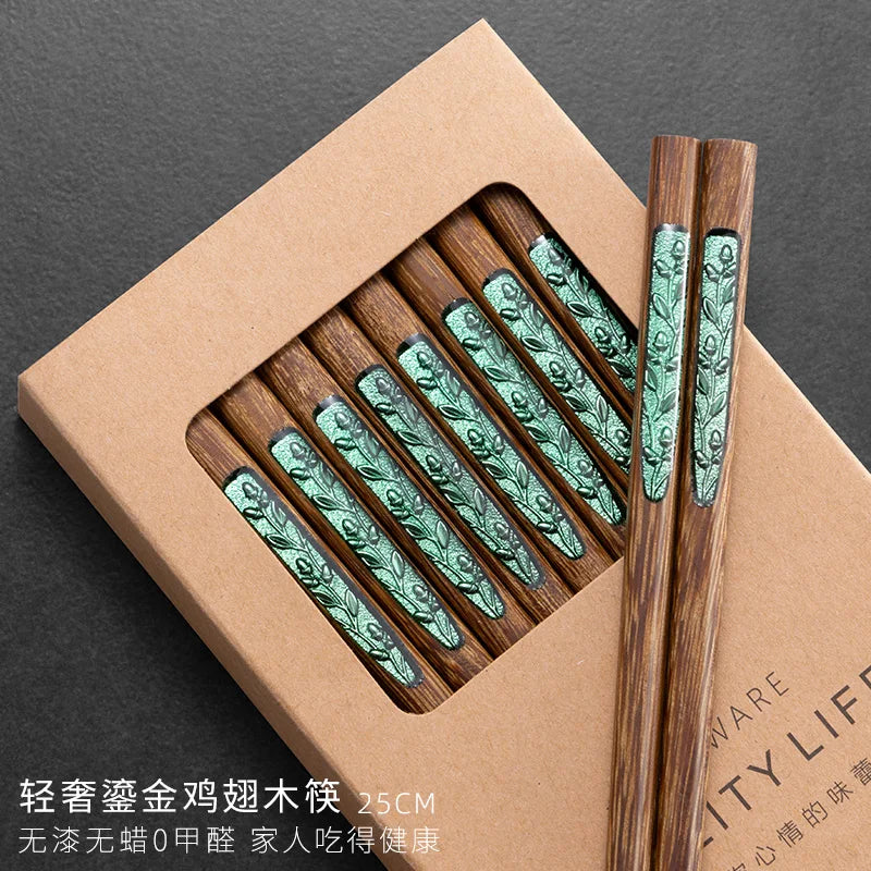 Wooden kawaii chopsticks with green patterns in a brown box on a dark background