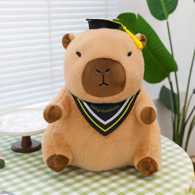 Graduation-themed kawaii plush bear with a cap and tassel on a checkered tablecloth.