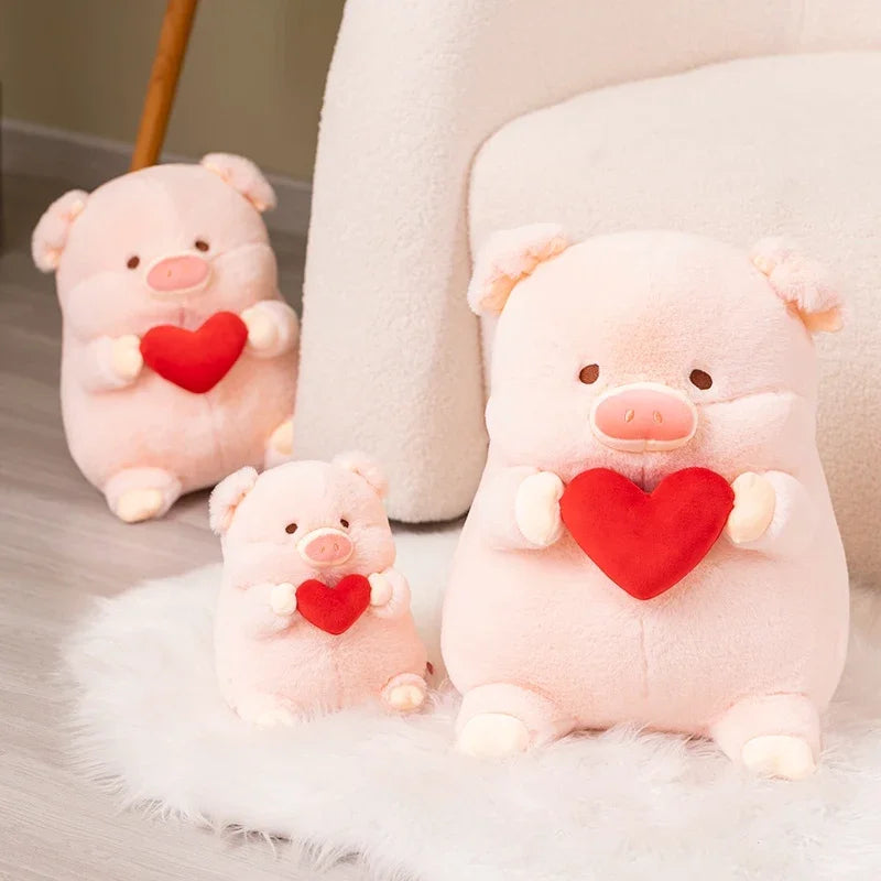 Three pink kawaii plush pigs holding red hearts on a soft surface.