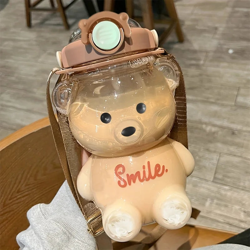 Clear bear-shaped kawaii water bottle with a brown helmet and 'Smile' text, held by a person.