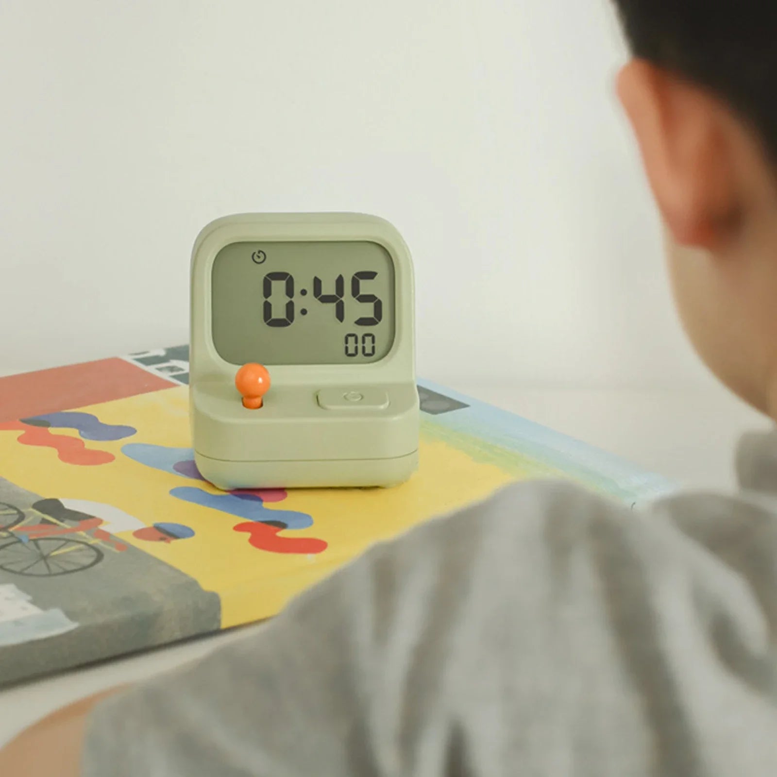 Child looking at a kawaii digital timer on a colorful surface
