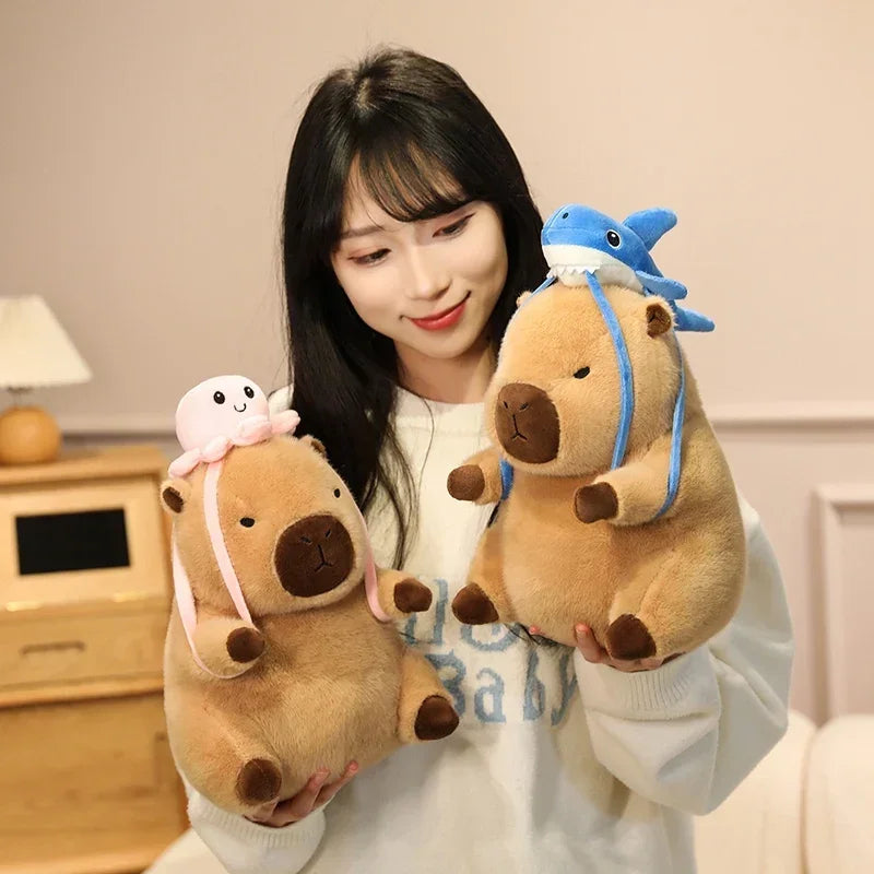 Woman holding two kawaii plush toys resembling beavers with animal hats in a room.