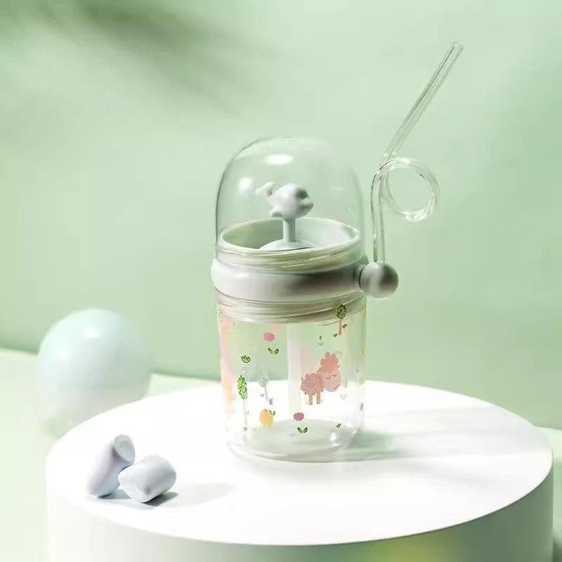Clear kawaii tumbler with a lid and straw on a white surface against a light green background