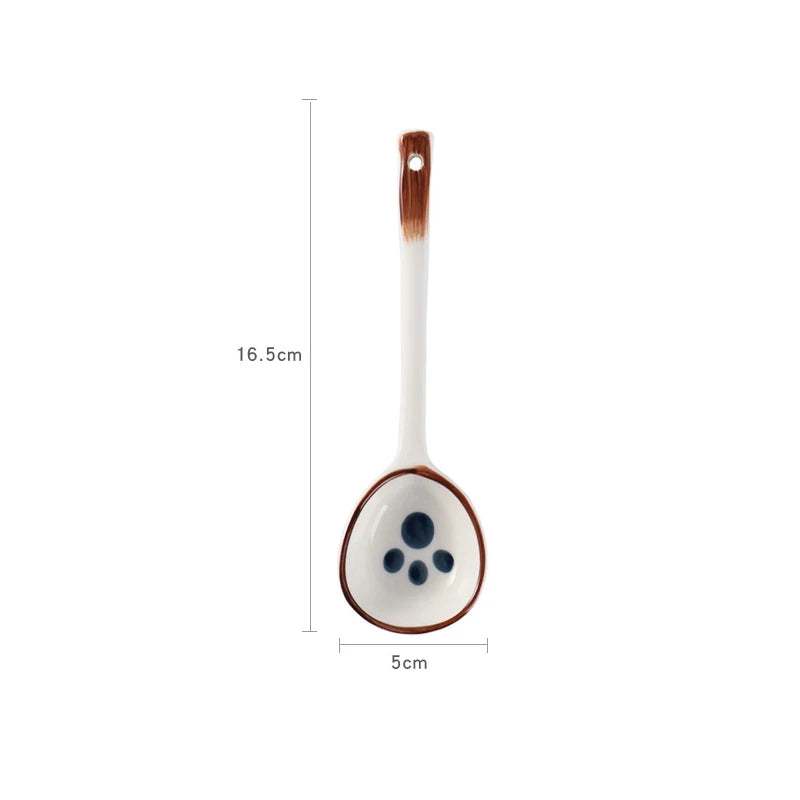 A white ceramic kawaii spoon with a glover on it