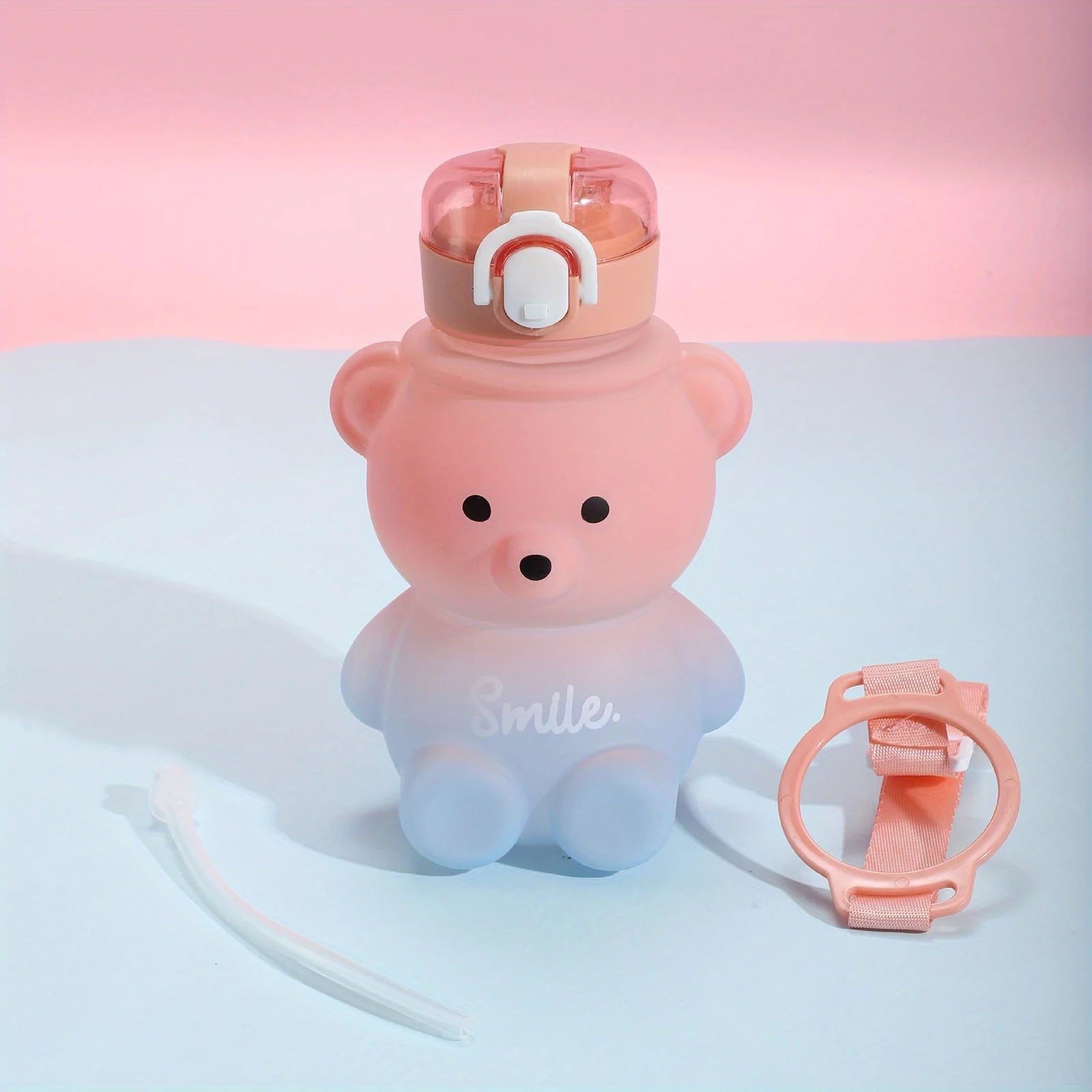Pink bear-shaped kawaii water bottle with a cap and holder on a gradient background