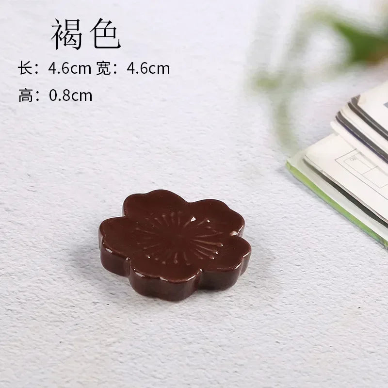 Brown flower-shaped kawaii chopstick holder on a textured white surface with text indicating dimensions.