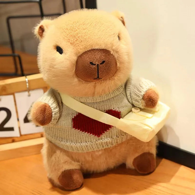 Kawaii plush bear toy wearing a sweater with a heart design, holding a book on a wooden surface.