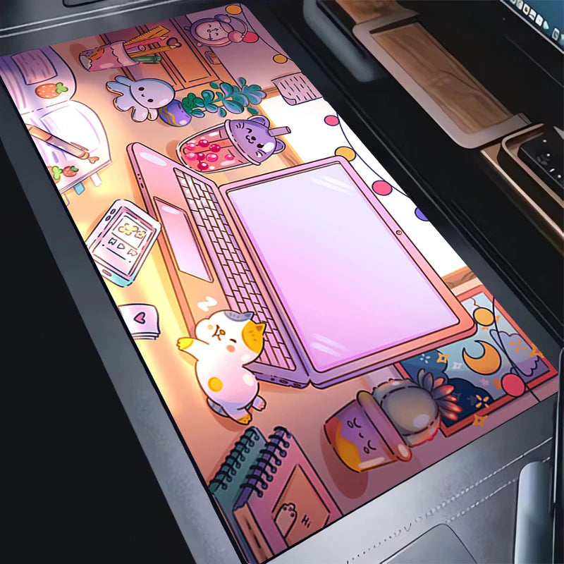 A close-up of a laptop trackpad or desk mat featuring a colorful cartoon illustration with a laptop, cat, notebook, and pastel objects, shown on a dark desk surface.