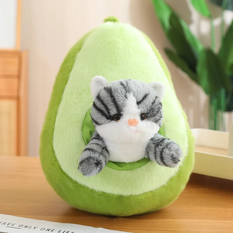 Kawaii plush toy cat inside a green avocado-shaped cushion on a wooden surface.